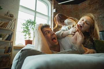 Image showing Family spending nice time together at home, looks happy and cheerful, lying down together