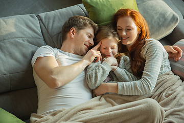 Image showing Family spending nice time together at home, looks happy and cheerful, lying down together