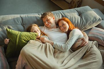 Image showing Family spending nice time together at home, looks happy and cheerful, lying down together