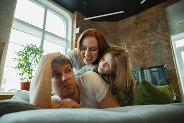 Image showing Family spending nice time together at home, looks happy and cheerful, lying down together