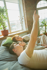 Image showing Family spending nice time together at home, looks happy and cheerful, lying down together