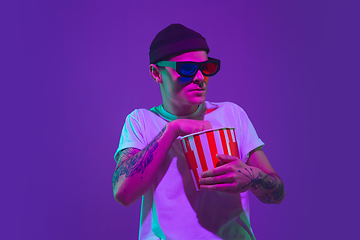 Image showing Caucasian man\'s portrait isolated on purple studio background in neon light, cinema concept