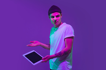 Image showing Caucasian man\'s portrait isolated on purple studio background in neon light