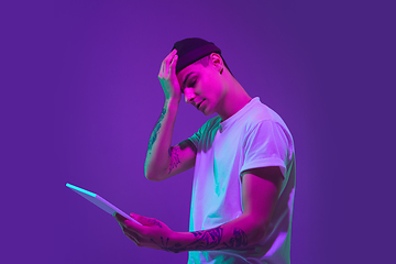 Image showing Caucasian man\'s portrait isolated on purple studio background in neon light