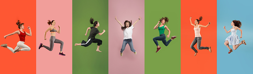 Image showing Young emotional people jumping high, look happy and cheerful on multicolored background