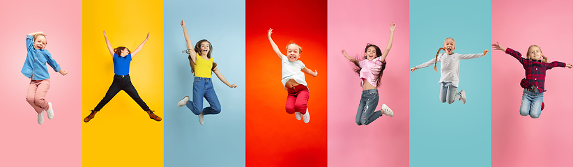 Image showing Emotional kids and teens jumping high, look happy and cheerful on multicolored background