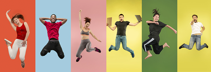 Image showing Young emotional people jumping high, look happy and cheerful on multicolored background