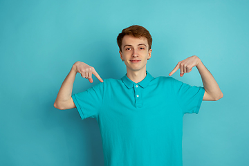 Image showing Caucasian young man\'s monochrome portrait on blue studio background, emotinal and beautiful