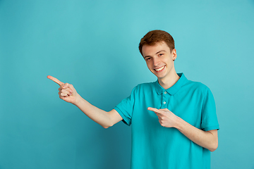 Image showing Caucasian young man\'s monochrome portrait on blue studio background, emotinal and beautiful