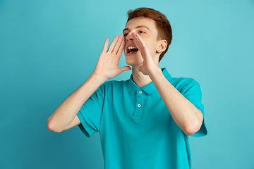 Image showing Caucasian young man\'s monochrome portrait on blue studio background, emotinal and beautiful