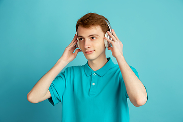 Image showing Caucasian young man\'s monochrome portrait on blue studio background, emotinal and beautiful