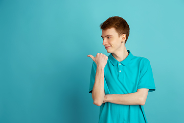 Image showing Caucasian young man\'s monochrome portrait on blue studio background, emotinal and beautiful