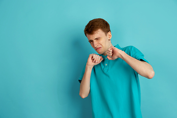 Image showing Caucasian young man\'s monochrome portrait on blue studio background, emotinal and beautiful