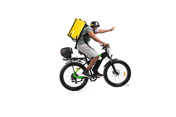 Image showing Too much orders. Contacless delivery service during quarantine. Man delivers food and shopping bags during isolation, wearing helmet and face mask.