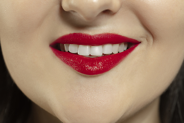 Image showing Close-up female mouth with bright red gloss lips make-up. Cosmetology, dentistry and beauty care, emotions