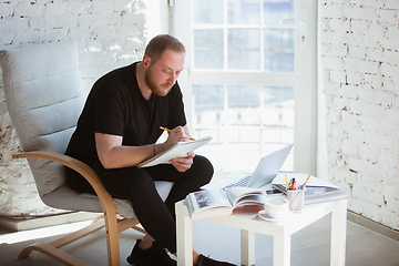 Image showing Young man studying at home during online courses for programmer, bug-tester, consulter