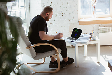 Image showing Young man studying at home during online courses for programmer, bug-tester, consulter