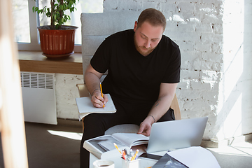 Image showing Young man studying at home during online courses for teacher, medical service manager