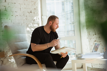 Image showing Young man studying at home during online courses for managers, marketers, buyers