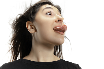 Image showing Smiling girl opening her mouth and showing the long big giant tongue isolated on white background, crazy and attracted