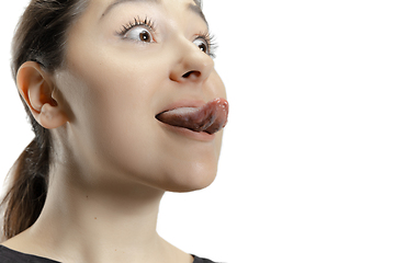 Image showing Smiling girl opening her mouth and showing the long big giant tongue isolated on white background, crazy and attracted