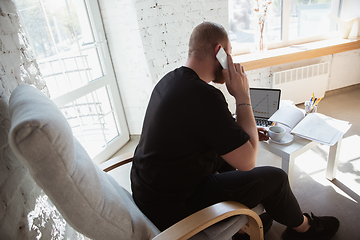 Image showing Young man studying at home during online courses for analytics, financists, economists