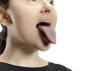 Image showing Smiling girl opening her mouth and showing the long big giant tongue isolated on white background, crazy and attracted