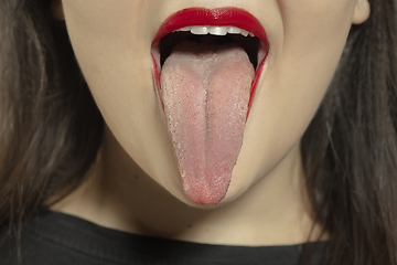 Image showing Smiling girl opening her mouth with red lips and showing the long big giant tongue isolated on white background, crazy and attracted, close up