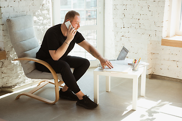 Image showing Young man studying at home during online courses for analytics, financists, economists