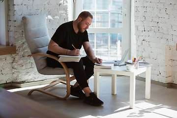 Image showing Young man studying at home during online courses for teacher, medical service manager