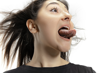 Image showing Smiling girl opening her mouth and showing the long big giant tongue isolated on white background, crazy and attracted