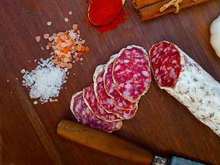 Image showing traditional Italian salame cured sausage sliced on a wood board