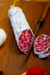 Image showing traditional Italian salame cured sausage sliced on a wood board