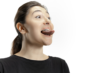 Image showing Smiling girl opening her mouth and showing the long big giant tongue isolated on white background, crazy and attracted