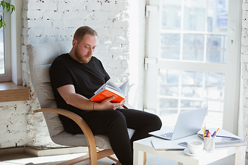 Image showing Young man studying at home during online courses for programmer, bug-tester, consulter