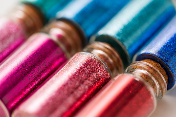 Image showing set of different glitters in small glass bottles