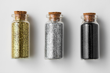 Image showing set of glitters in bottles over white background