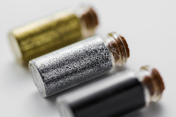 Image showing set of glitters in bottles over white background