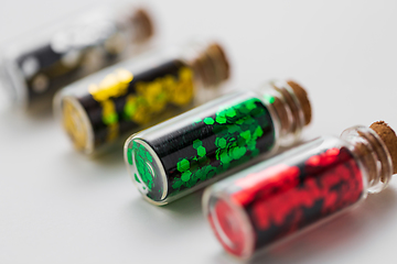 Image showing set of glitters in bottles over white background