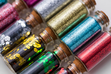 Image showing set of different glitters in small glass bottles