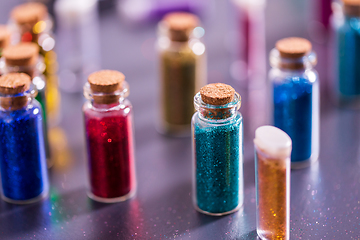 Image showing set of different color glitters in bottles