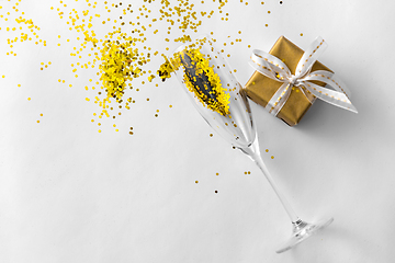 Image showing champagne glass, gift and golden glitters