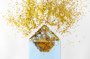 Image showing golden glitters and envelope on white background