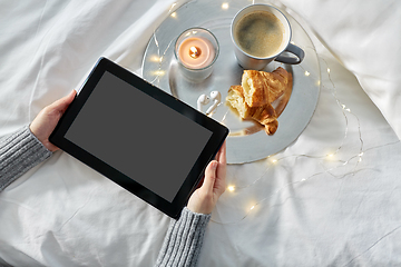 Image showing hands with tablet pc, croissant and coffee in bed