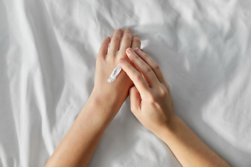 Image showing woman applying hand cream at home