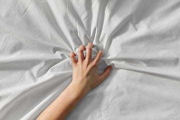 Image showing hand of woman squeezing white bed sheet