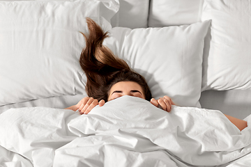 Image showing woman lying in bed under white blanket or duvet