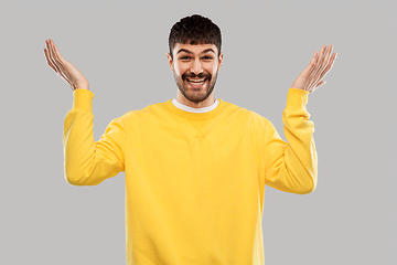 Image showing smiling young man in yellow sweatshirt