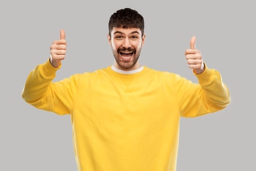 Image showing smiling young man showing thumbs up