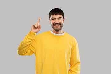 Image showing young man showing one finger in yellow sweatshirt